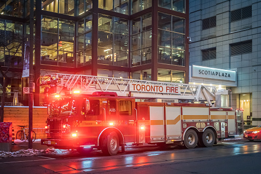 Toronto, Canada - November 14, 2019: Toronto Fire Department truck with siren lights turned on near Scotia Plaza