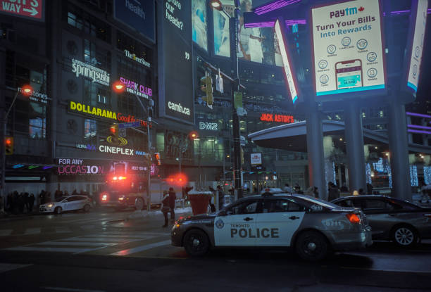 Billboards, rescue cars and pedestrians at Yonge - Dundas Square at nigh Toronto, Canada - March 15, 2019 :  Billboards , police and a fire department cars at Yonge - Dundas Square at nigh toronto dundas square stock pictures, royalty-free photos & images