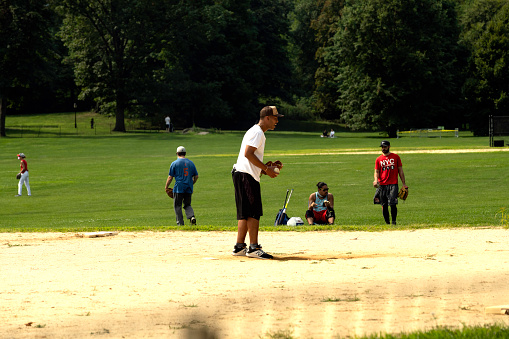 Little beginner baseball player in sports uniform playing baseball isolated on white background. Concept of sport, achievements, competition. School age boy learning to play baseball