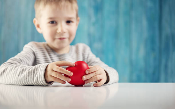 istock Cute little child holding red heart in hands. 1268292134