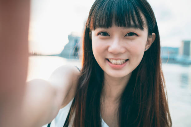 아시아 여자 미소 셀카를 가지고 - 자화상 촬영 뉴스 사진 이미지