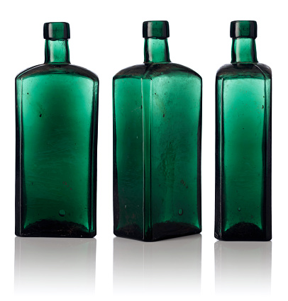 Old empty bottles isolated on a white background. Dusty bottles from color glass.