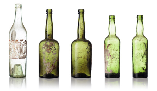 Old empty bottles isolated on a white background. Dusty bottles from color glass.