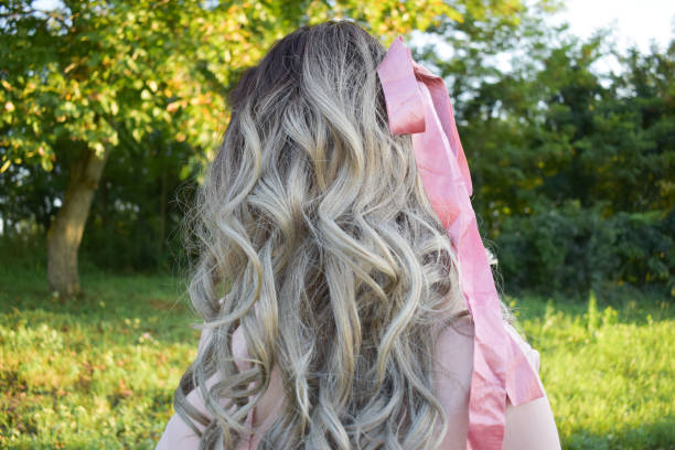 istock Woman outdoors with pink bow in hair 1268295949