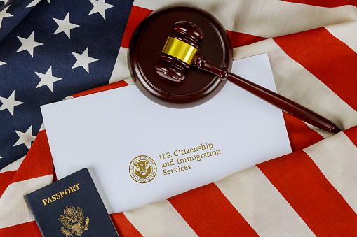 Wooden gavel justice law with Official department U.S deportation USCIS Department of Citizenship Immigration Security United States on American flag in New York, NY, United States