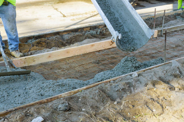 istock Labour builders at construction site filling formwork with cement workmen in the process forming foundation concrete 1268296551