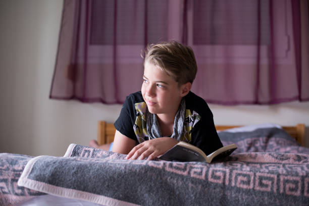 istock Teenage boy is reading a book 1268296667