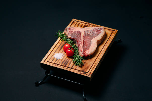 istock Raw meat steak t-bone on a black background. 1268298877