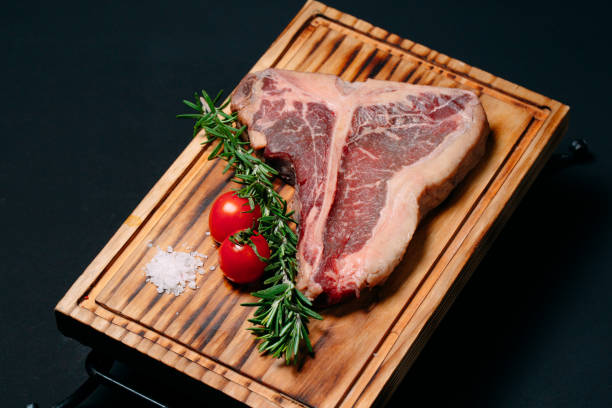 istock Raw meat steak t-bone on a black background. 1268298892
