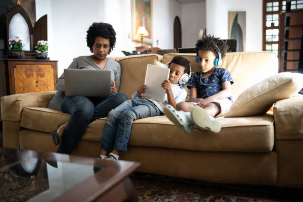 집에서 휴대용 정보 장치를 사용하는 어머니와 아들 - laptop women child digital tablet 뉴스 사진 이미지