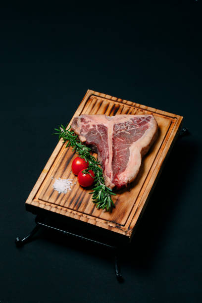 istock Raw meat steak t-bone on a black background. 1268299083