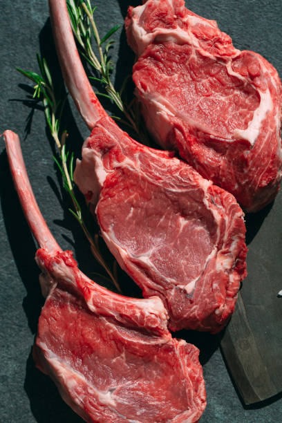 istock Raw steak with a meat cleaver on a dark stone background. 1268301640