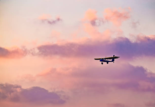 istock silhouette of ultralight microlite aircraft flying with a pilot and a passenger against sunset sky. 1268303048