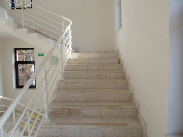 istock Light marble steps with white railings, white walls and windows with dark frames 1268303229