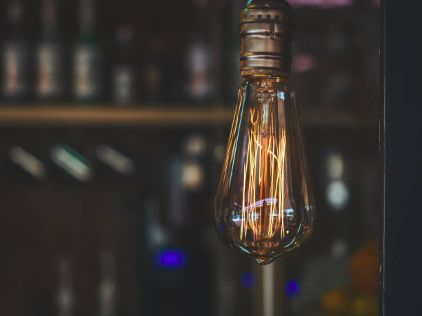 istock Transparent lamp with bright yellow orange wick on dark blurred background 1268304144