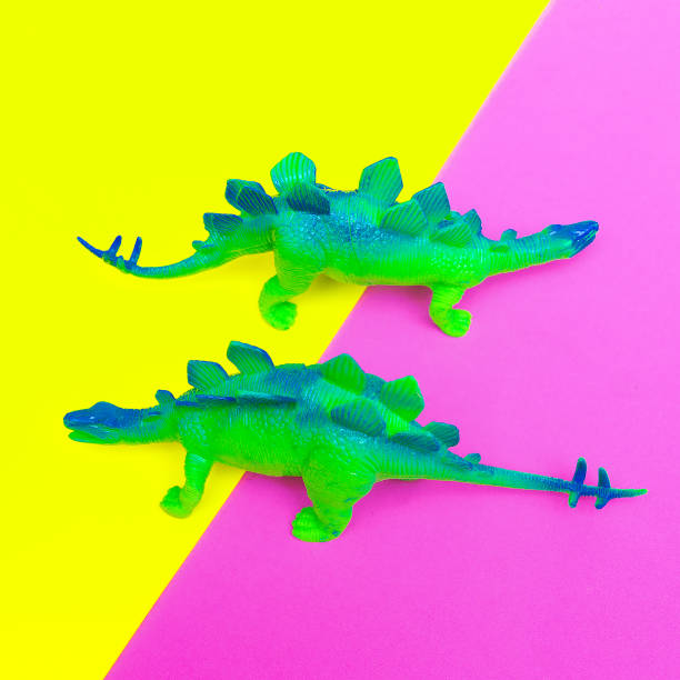 istock Plastic two green dinosaurs on colored background. Minimal flat lay art. 1268305443