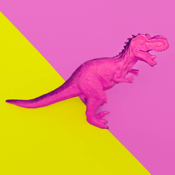 istock Pink Dinosaur toy on colored background. Minimal flat lay art. 1268305955