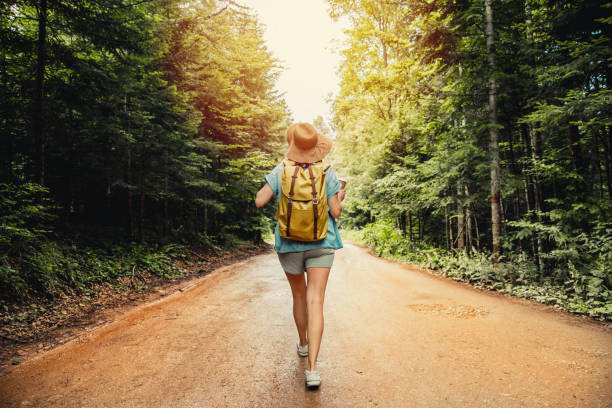 Woman with backpack hiking in the forest