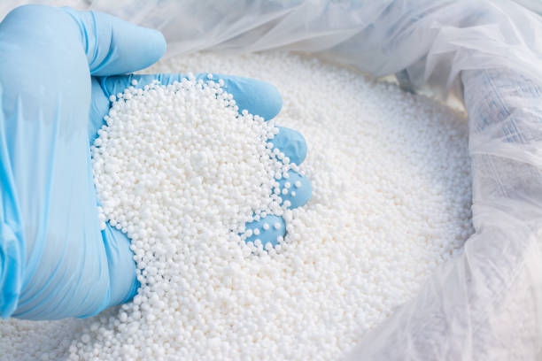 istock Hand in blue glove holds white fertilizer for plants 1268317935