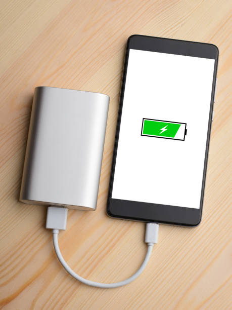 istock Modern smartphone lays on light wooden table while charging with power bank with quick charge 1268318034