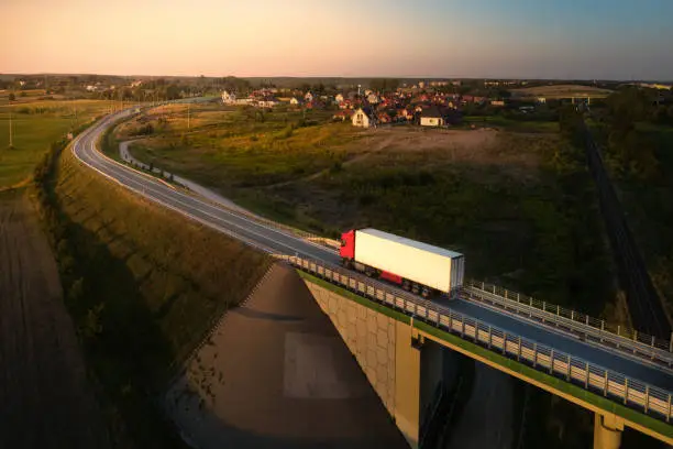 White truck driving on the bypass at sunset.