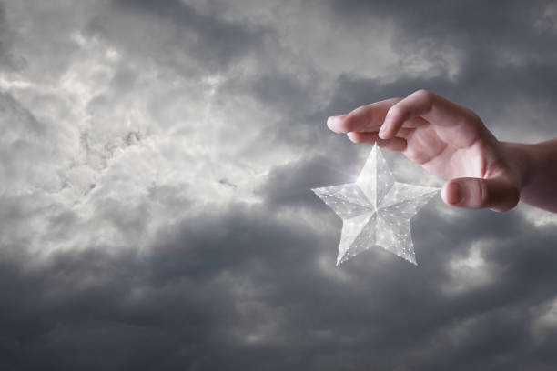 istock Hand clicks on a star against the sky. 1268329684