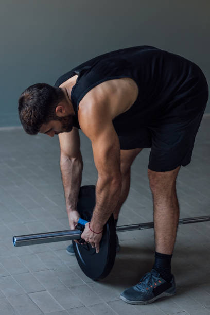 istock Athlete Exercising by Lifting Barbells, cross training Strength Training Concept 1268332742