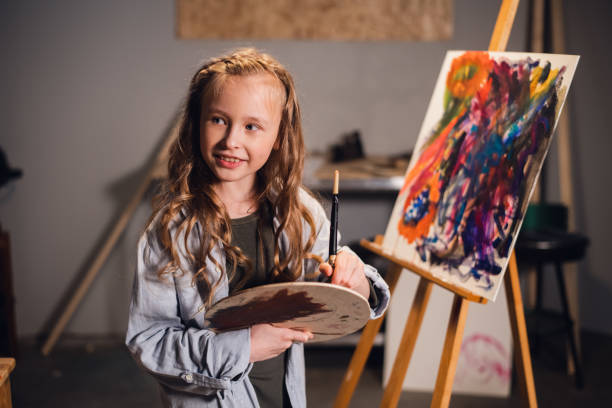 istock Young girl creative artist at work in a workshop. With passion draws a picture immersed in work 1268340966