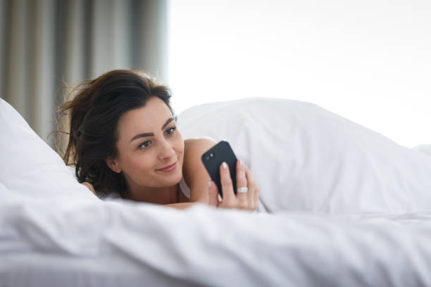 istock Beautiful young woman sleeping using her smart phone in bed first thing in the morning 1268341793