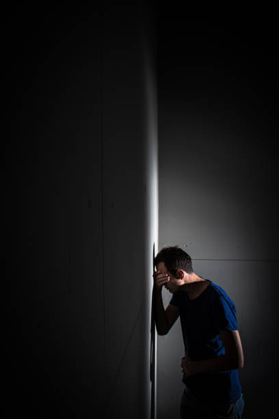 Young man suffering from severe belly pain, being cornered by the debilitating condition of celiak disease/Crohn's disease/autoimune disease