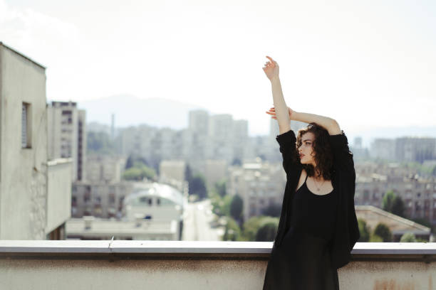 istock Girl on rooftop flirting with camera during the sunset by herself. 1268344254