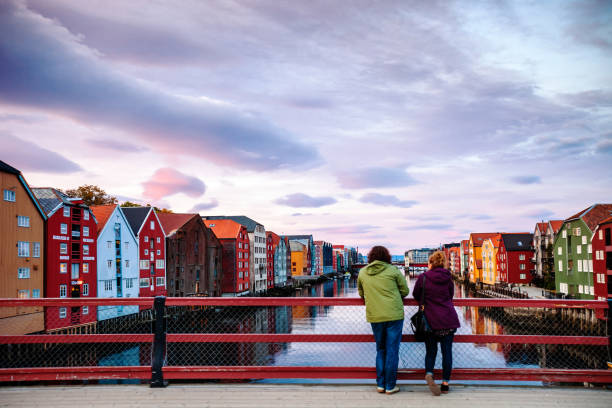 Trondheim, Norway - Tourist taking pictures of sunset on the old bridge