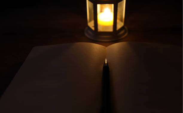 istock Candle Lantern,Blank Notebook And Pen Concept In Dark Atmosphere 1268345840