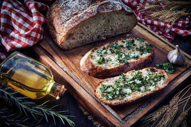 istock Snack or appetizer of garlic basil and olive oil bruschetta on table in a rustic kitchen 1268350077