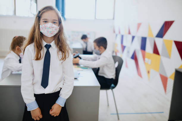 istock Child with face mask back at school after covid-19 quarantine and lockdown 1268356087