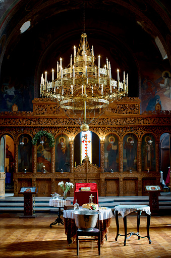 A baptismal font, bronze chandelier,\na throne and altar in the Orthodox Church