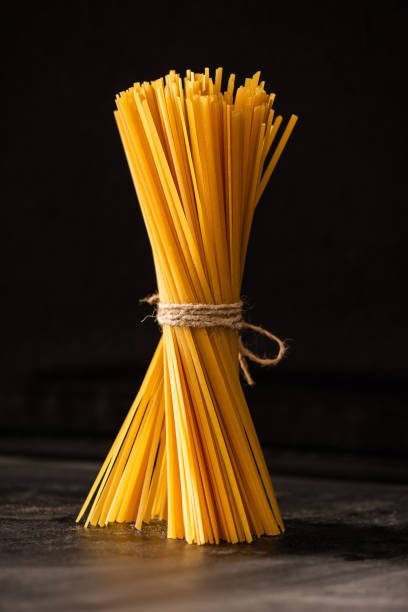 istock tied uncooked Italian spaghetti isolated on black 1268359830