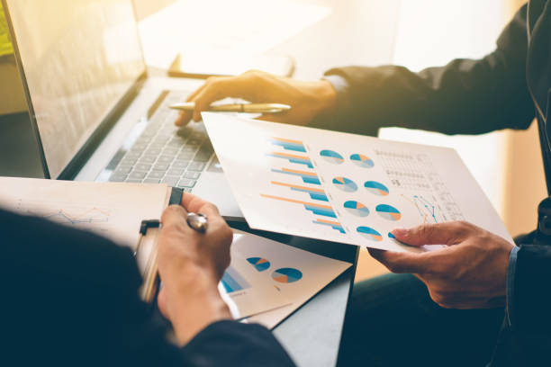 istock Businessman analysis on Graph data paper  using calculator, finance concept in office. 1268368950