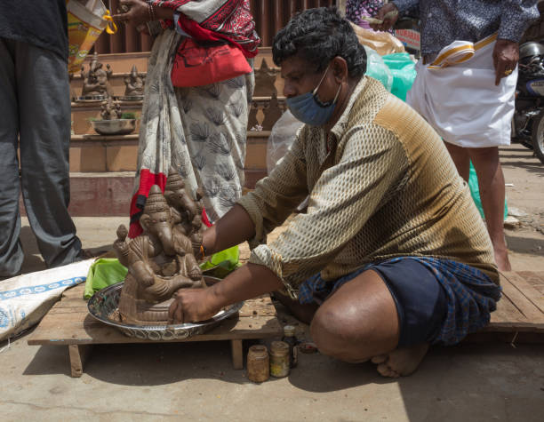 uma cena de mercado da cidade onde um artista de clay está vestindo o ídolo ganesha para ser entregue durante o festival em mysuru, karnataka/india. - shiv bangalore shiva god - fotografias e filmes do acervo