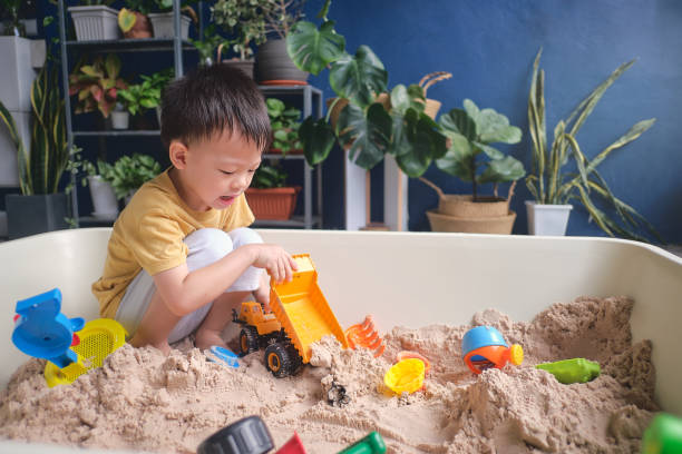 mignon jeune garçon asiatique jouant avec le sable seul kid jouant avec des jouets de sable dans le jardin urbain à la maison, éducation montessori, jeu créatif pour le concept d’enfants - sandbox child human hand sand photos et images de collection