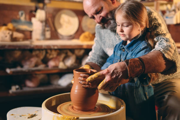 istock Pottery workshop. Grandpa teaches granddaughter pottery. Clay modeling 1268389194
