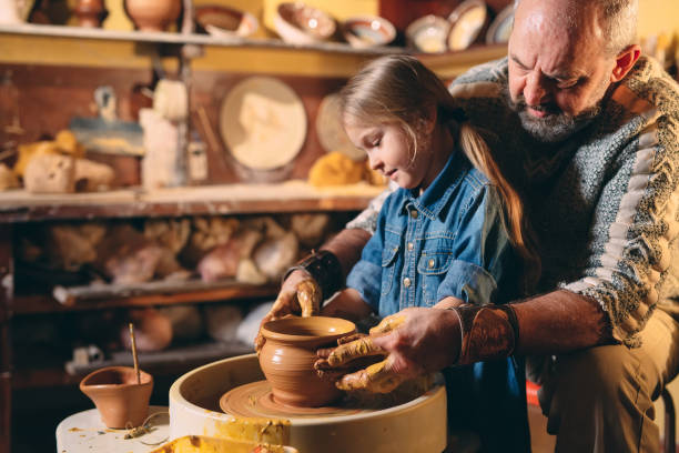 istock Pottery workshop. Grandpa teaches granddaughter pottery. Clay modeling 1268389216