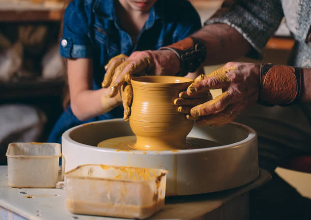 istock Pottery workshop. Grandpa teaches granddaughter pottery. Clay modeling 1268389242