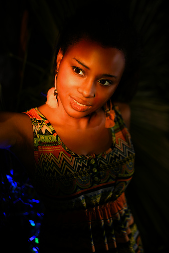 Young woman in dress with color lights behind her