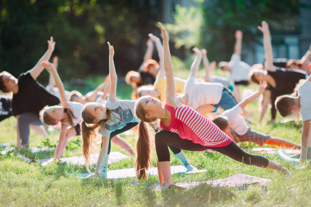 aulas de yoga lá fora ao ar livre. crianças yoga, - child exercising sport yoga - fotografias e filmes do acervo