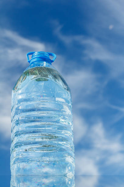 istock Big water bottle on a mirror surface with blue sky on background 1268392415