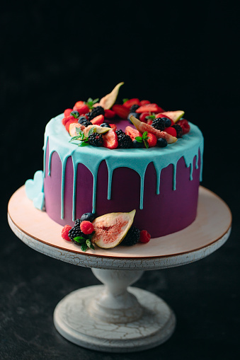 Fruit cake decorated with figs, blueberries, raspberries and mint