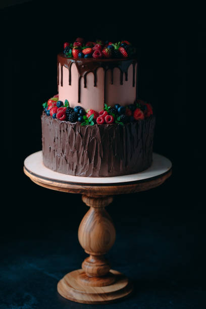 istock Fruit chocolate cake on wooden stand on black background. 1268392611