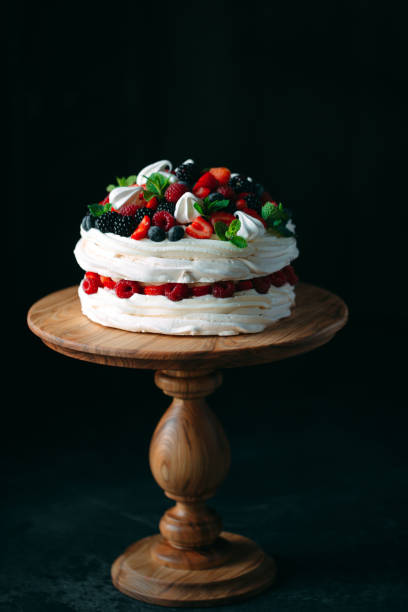 istock Fruit cake. Cake decorated with berries on a wooden stand on a black background. 1268392655