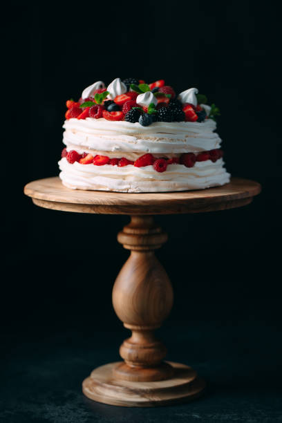 istock Fruit cake. Cake decorated with berries on a wooden stand on a black background. 1268392747